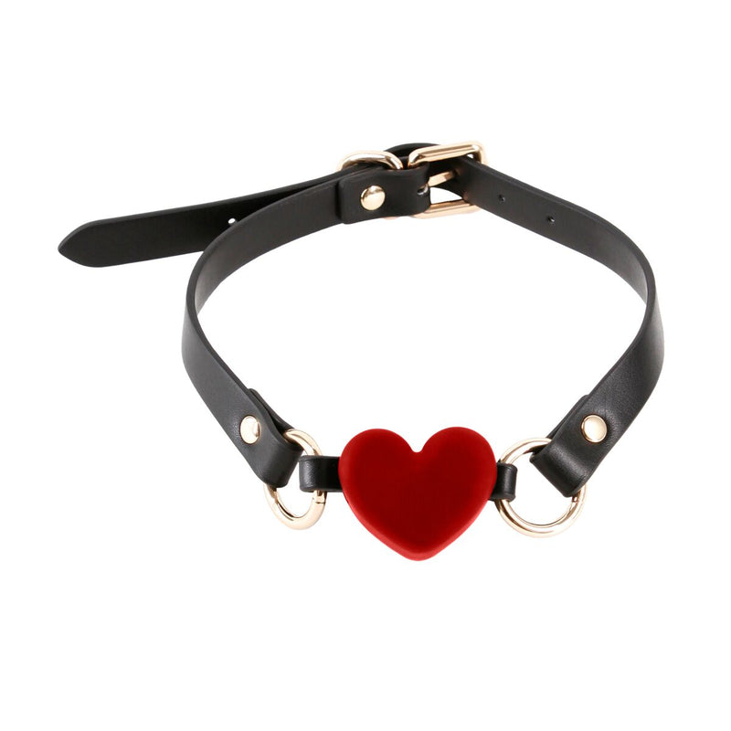 Zwarte ballgag met rood hartdetail, symbool voor stilte, richting en intieme afstemming.